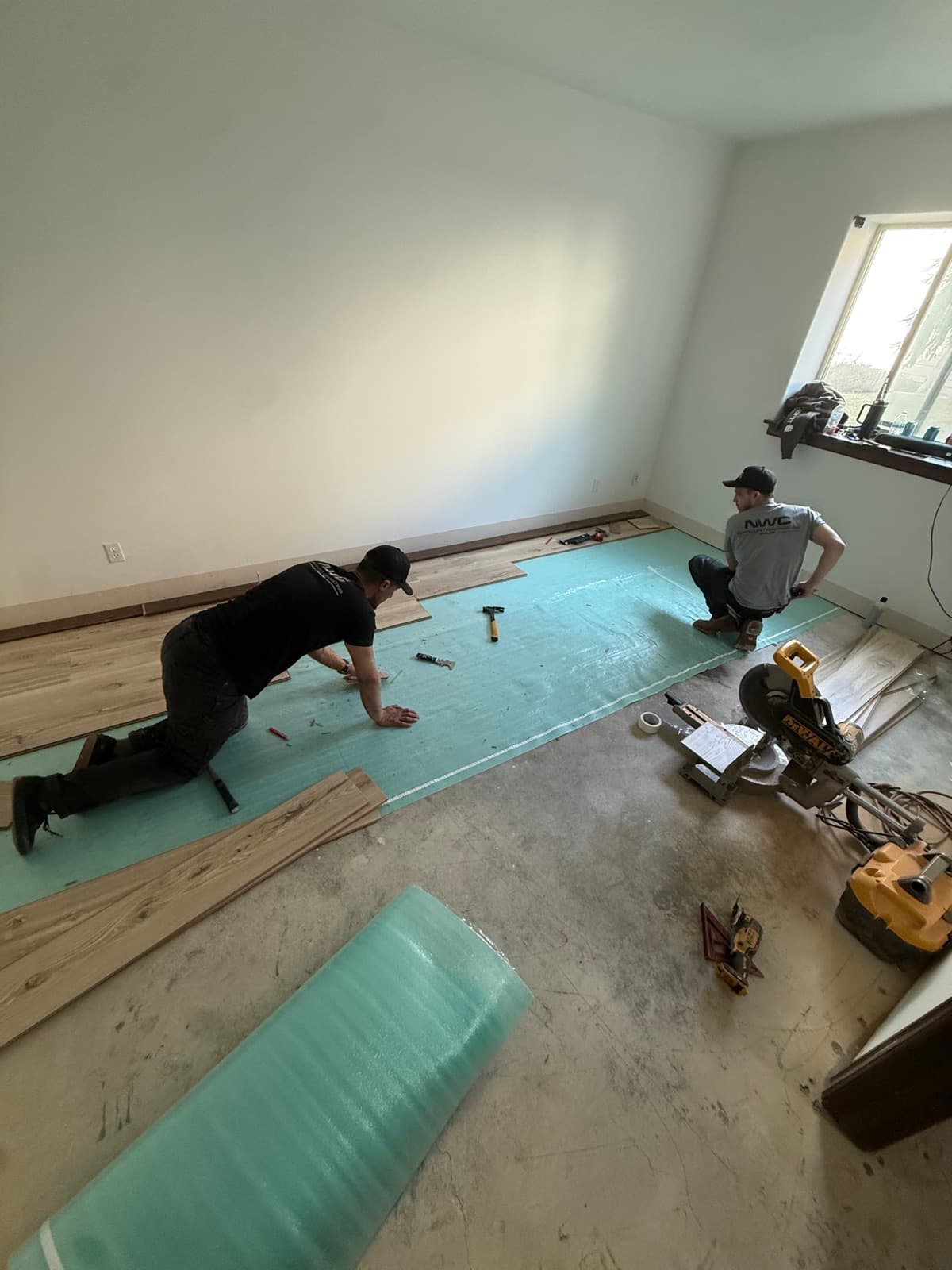 Happy Feet Flooring crew installing luxury vinyl plank over underlayment in Spokane